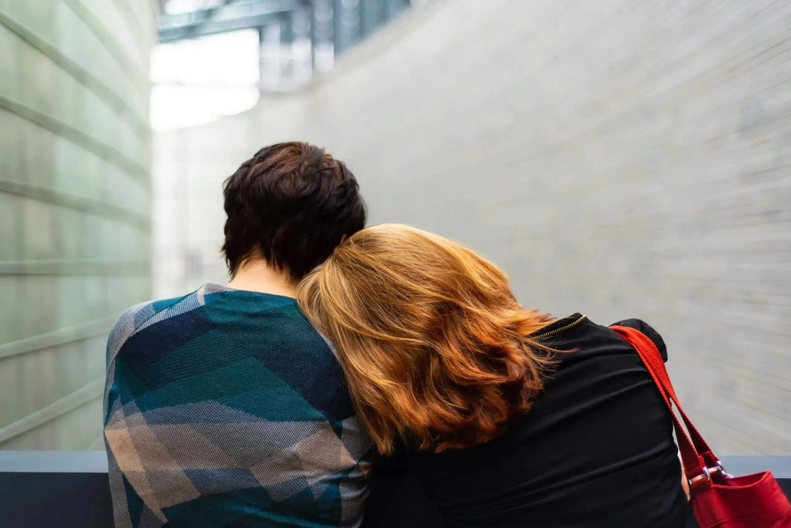 Femme réconfortant une autre femme en posant sa tête sur son épaule.